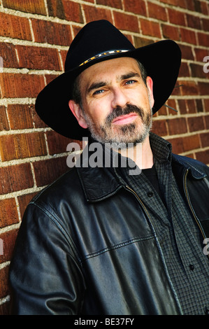 Mann mit Bart in Cowboy-Hut und Lederjacke Stockfoto