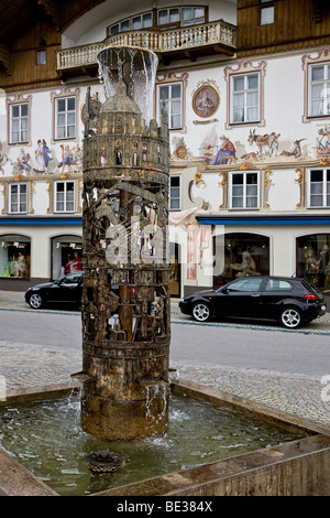 Ein Brunnen vor einem schönen bemalten Haus in Oberammergau, Bayern, Deutschland, Europa Stockfoto