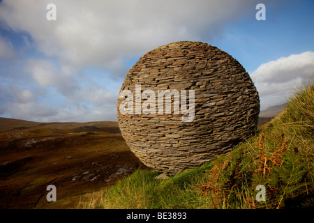 Knockan Crag Trail Stone Ball und Kipp Globe Skulptur. National Nature Reserve. Creag A Chnocain Tearmann Nadair Rock Art Highlands, Schottland, Großbritannien. Stockfoto