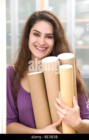 Mädchen hält Pappe rollt Stockfoto