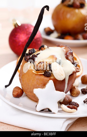 Bratapfel mit Vanillesoße, gefüllt mit Nüssen, Marzipan und m, festliche Atmosphäre Stockfoto