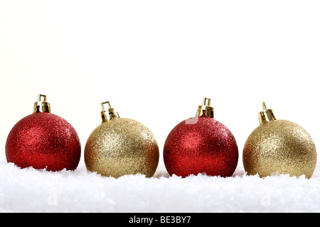 Roter und goldener Baum Weihnachtskugeln auf Schnee Stockfoto