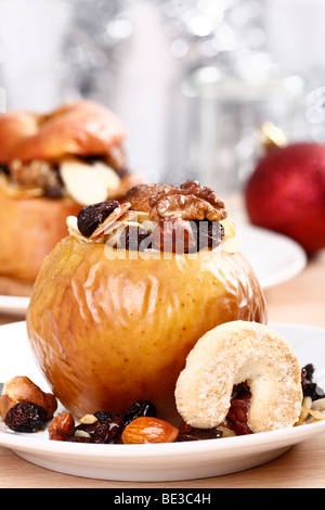 Gebackener Apfel gefüllt mit Nüssen, Marzipan und Rosinen, festliche Atmosphäre Stockfoto