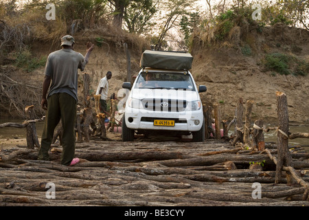 All - Terrain-Fahrzeug der Luangwa River, North Luangwa Nationalpark, Sambia, Af eine Pontonbrücke und Holzbrücke überqueren. Stockfoto