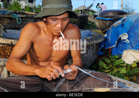 Junge Fischer Reparatur sein Netz, Mui Ne, Vietnam, Asien Stockfoto