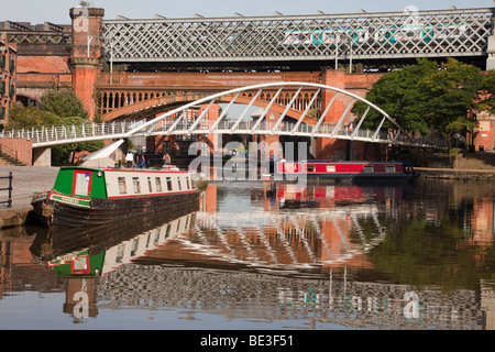 Der Bridgewater Canal Basin reflektierende narrowboats und Kaufleute Brücke in Conservation Area. Castlefield Urban Heritage Park, Manchester, England, Großbritannien Stockfoto