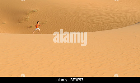 Frau läuft über Sanddünen und Strukturen in der Nähe von Mui Ne, roten Sanddünen, Vietnam, Asien Stockfoto