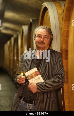 Winzer Reinhard Heymann-Loewenstein, Inhaber des Weinguts Heymann-Loewenstein in seinem Weinkeller mit seinem Buch "Terr Stockfoto