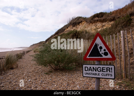 Schild Warnung vor instabilen Klippen und Felsen im Hintergrund Stockfoto