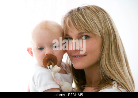Ein ein-Jahr-alte Mädchen auf dem Arm der Mutter Stockfoto