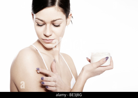 Junge Frau mit Hautcreme Stockfoto