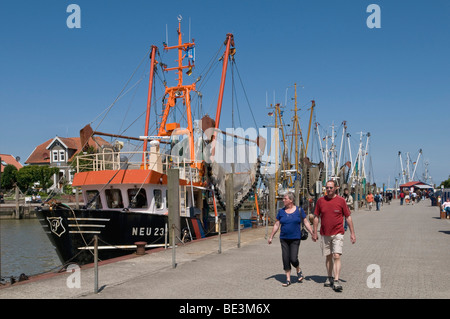 Touristen, neben der Flotte von Garnelen Boote im Hafen Neuharlingersiel, Nordsee, Ostfriesland, Niedersachsen, Deutschland, Europa Stockfoto