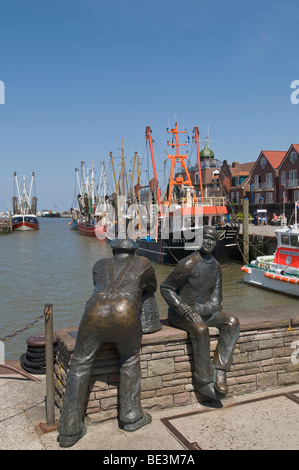 Bronze-Skulptur von der alten Fischer und junge Fischer im Hafen Neuharlingersiel, in den hinteren Krabbenkutter, Nordsee, Eas Stockfoto