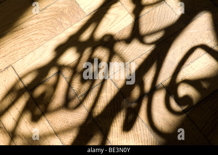 Alte Treppe Geländer Gießen Schatten auf Holzboden Stockfoto