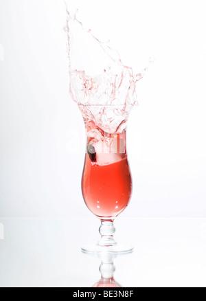 Eiswürfel in ein Glas roter Flüssigkeit, Saft, cocktail Stockfoto