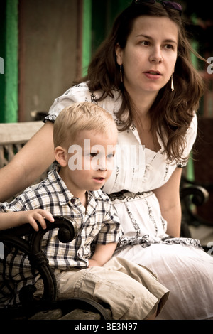 Schwangere Mutter und Sohn sitzen auf einer Bank im retro-Stil Stockfoto