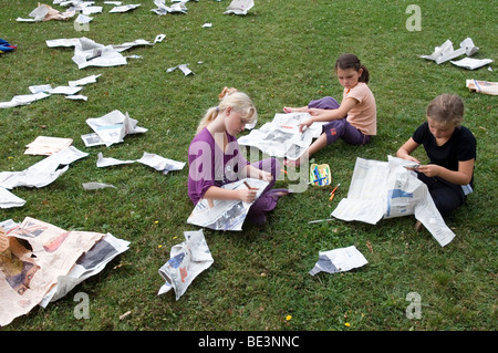 Kinder machen Tücher mit alten Zeitungen Stockfoto
