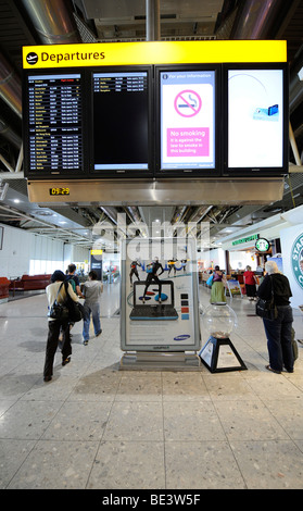 Anzeige Brett und Passagiere am Flughafen-Gate, Wartebereich, BAA Heathrow International Airport, Terminal 4, London, England, Stockfoto