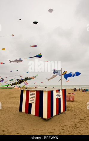 Drachen fliegen über eine gestreifte Hütte am Strand von Margate in Kent.  Foto von Gordon Scammell Stockfoto