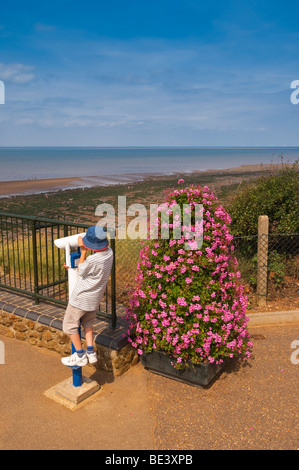 Eine Bezahlung an Teleskop Blick auf das Meer von einem kleinen Kind bei Hunstanton, North Norfolk, Großbritannien verwendet wird Stockfoto