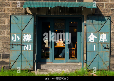 Alten steinernen Lagerhäuser an den Ufern des Kanals Otaru in Hokkaido, Japan laufen jetzt als noblen Restaurants und Souvenirläden. Stockfoto