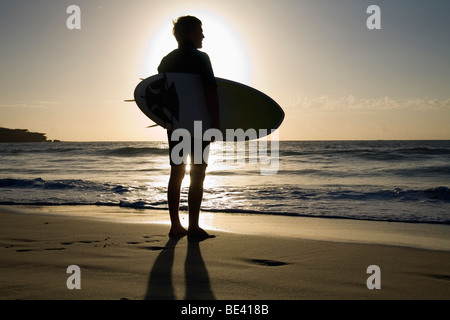 Eine Surfer mit Surfbrett wird von der Morgensonne Silhouette.  Bondi Beach. Sydney, New South Wales, Australien Stockfoto