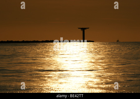 Sonnenuntergang, die untergehende Sonne über Hoek Van Holland Dyke dam orange bunten Abend ruhige Meer Horizont weit entfernten Reflexion reflektiertes Licht Stockfoto