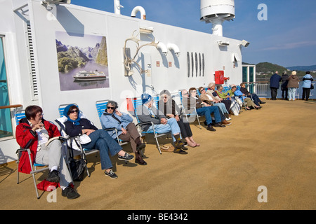 Passagiere genießen Sie die Sonne an Bord der MS Trollfjord, einer der 12 Hurtigruten-Schiffe unter Passagieren und Fracht entlang Norwegens Küste Stockfoto