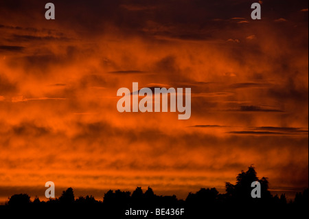 Linsenförmige Wolken im Bild gegen ein tief rot und Orange feurigen Sonnenuntergang Blick fast wie fremde Besucher in den Himmel Stockfoto