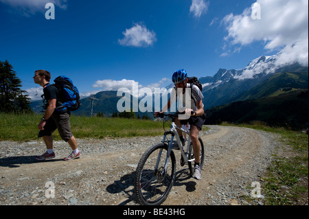 Mountainbiker, aufsteigend, Prarion, mit dem Mont-Blanc-Massiv im Hintergrund. Stockfoto