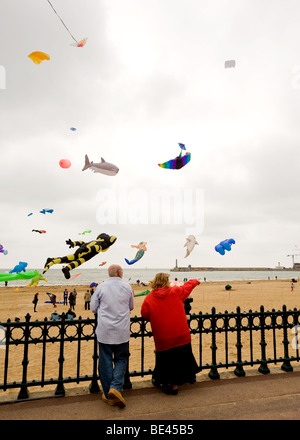 Zwei Leute zu beobachten ein Drachenfestival am Strand von Margate in Kent. Stockfoto