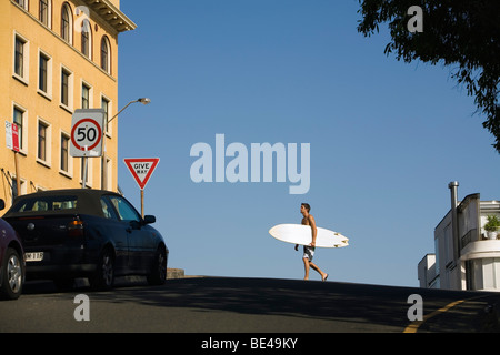 Mann mit Surfbrett Weg am Bondi Beach.  Sydney, New South Wales, Australien Stockfoto