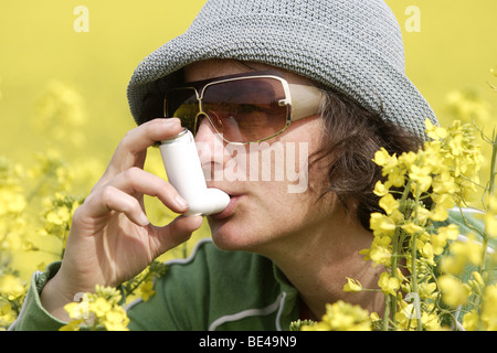 Eine Frau Im Rapsfeld Und Nimmt Ein Asthmaspray Stockfoto