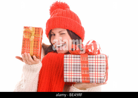 Hübsche junge Frau mit zwei Geschenke, die augenzwinkernd und lächelnd auf weißen Hintergrund isoliert Stockfoto