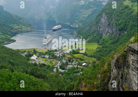 Blick auf das Dorf Geiranger mit Kreuzfahrtschiffen auf dem Geirangerfjord, Norwegen, Skandinavien, Europa Stockfoto