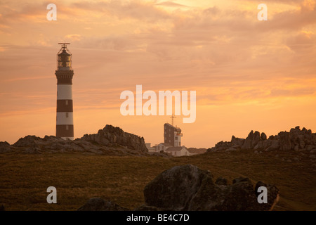 Ouessant felsige Küste der Insel in der Abenddämmerung mit creac'h Leuchtturm, Bretagne, Finistere, Frankreich Stockfoto