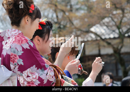 Junge Damen in Kimonos und mit Mobiltelefonen in der alten Stadt, Kyoto, Japan, Asien Stockfoto