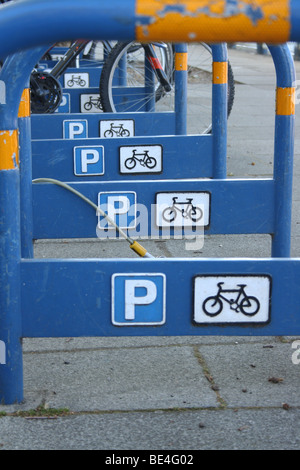 Reihe von starken und sicheren blau Metall Fahrradständer in der Straße mit Parkplatz und Zyklus Symbole auf Seiten in Putney, London, Vereinigtes Königreich. Stockfoto