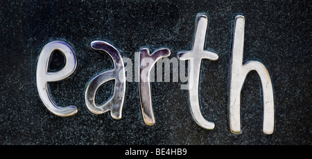 Das Wort Erde auf einem Stein Plakette in Metall verchromt Stockfoto