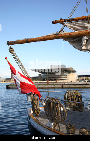 Das Königliche dänische Opernhaus am Ufer von Holmen, das durch das Rigg eines alten Segelschiffs im Hafen von Kopenhagen, Dänemark, gesehen wird. Stockfoto