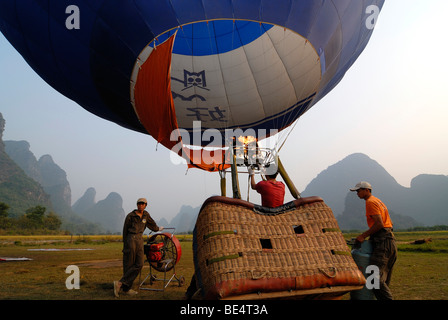 Drei chinesische Männer, die Vorbereitung der Einführung von einem Heißluftballon aus dem ersten chinesische Heißluft-Ballon-Club in Yangshuo, Guilin, Gu Stockfoto