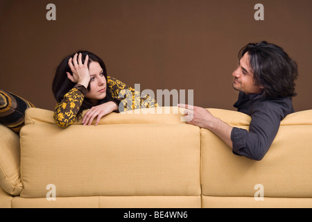 Mädchen stützte sich auf ein Sofa, im Gespräch mit ihrem Freund Stockfoto