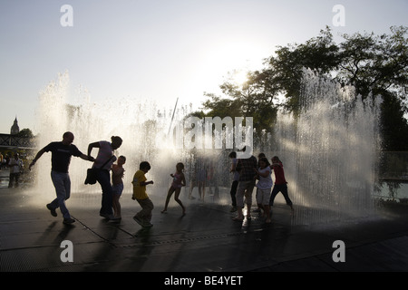 Städtischen Brunnen mit öffentlichen Interaktion, South bank London, Vereinigtes Königreich. Silhouetten gegen späten Nachmittag Sommersonne Stockfoto