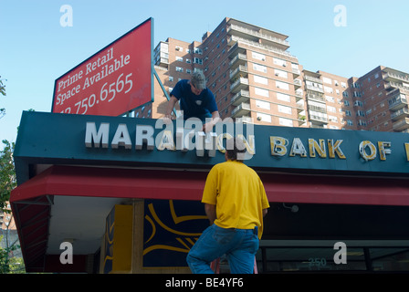 Arbeiter entfernen Sie die Buchstaben aus dem Zeichen für die Marathon-Bank of New York Branch im Stadtteil Chelsea von New York Stockfoto
