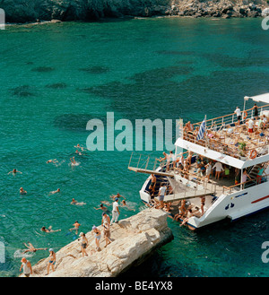 Schiff vor Anker mit Schwimmer in springen und Schwimmen im tiefblauen Wasser vor Skiathos in der Ägäis in Griechenland Stockfoto