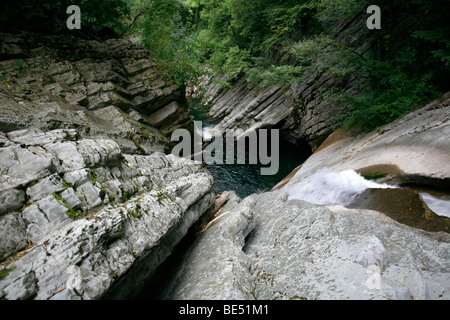 Regentropfen fallen auf Bändern aus Kalkstein ausgehöhlt durch den Breggia-Fluss, Felsformationen, Geopark Gole della Breggia Mendri gefaltet Stockfoto