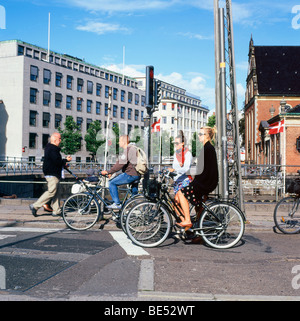 Stilvolle weibliche Pendler Radfahrer mit einer Gruppe von Menschen auf dem Fahrrad auf einer Straße an einem Verkehrsknotenpunkt wartet im Sommer in Kopenhagen Denmar KATHY DEWITT Stockfoto