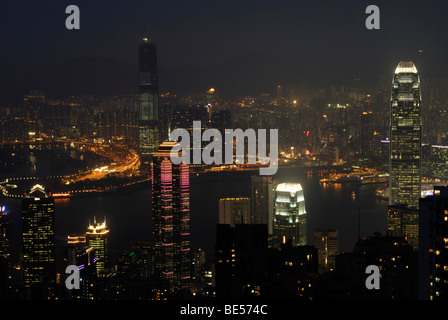 Blick vom Victoria Peak auf die beleuchtete Stadt von Hong Kong bei Nacht mit Hochhäusern und Wolkenkratzern Mittel-und K Stockfoto