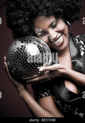 70er Jahre disco Mädchen mit einer Disco-Kugel und einer großen Afro-Haar Stockfoto
