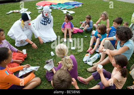 zwei Clowns Treffen einer Gruppe von Kindern während einer Sommer-camp Stockfoto